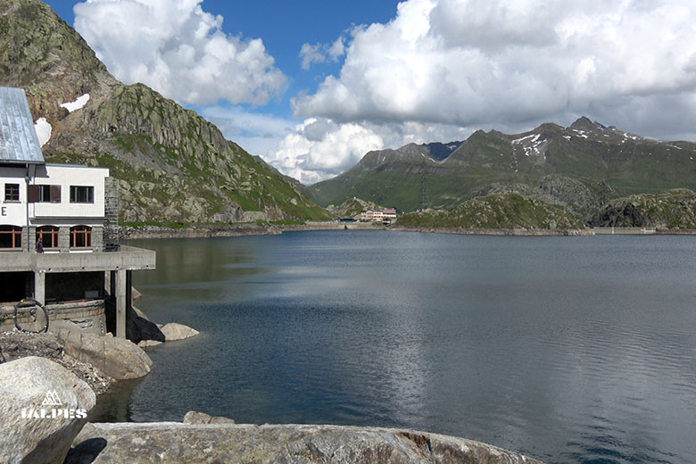 Lac Totensee au sommet du col du Grimsel avec montagnes enneigées en arrière-plan.